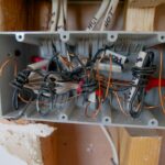 Detailed view of an open electrical switchboard with tangled wires and cables.